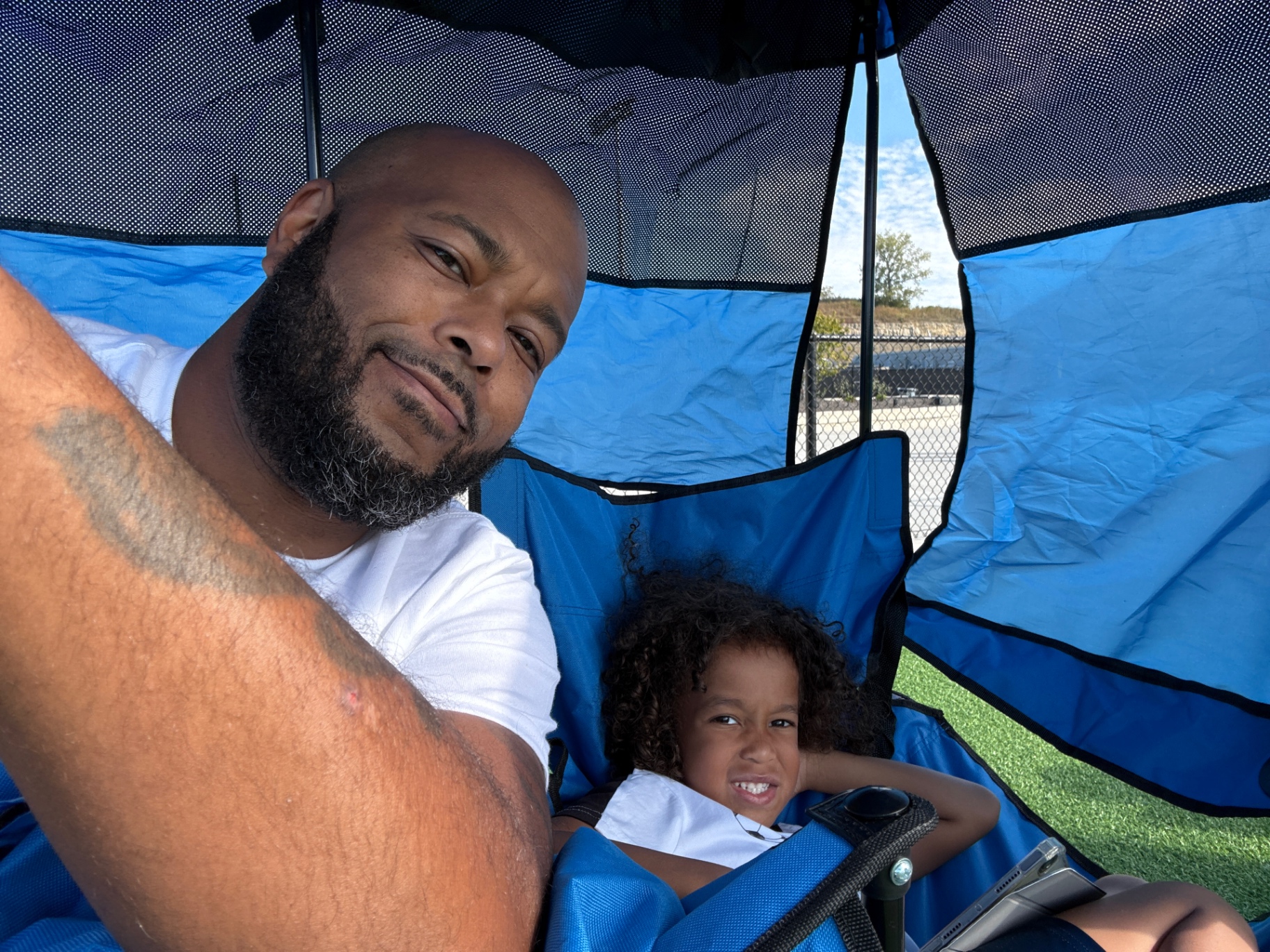 Remy and his youngest under the tent at soccer practice